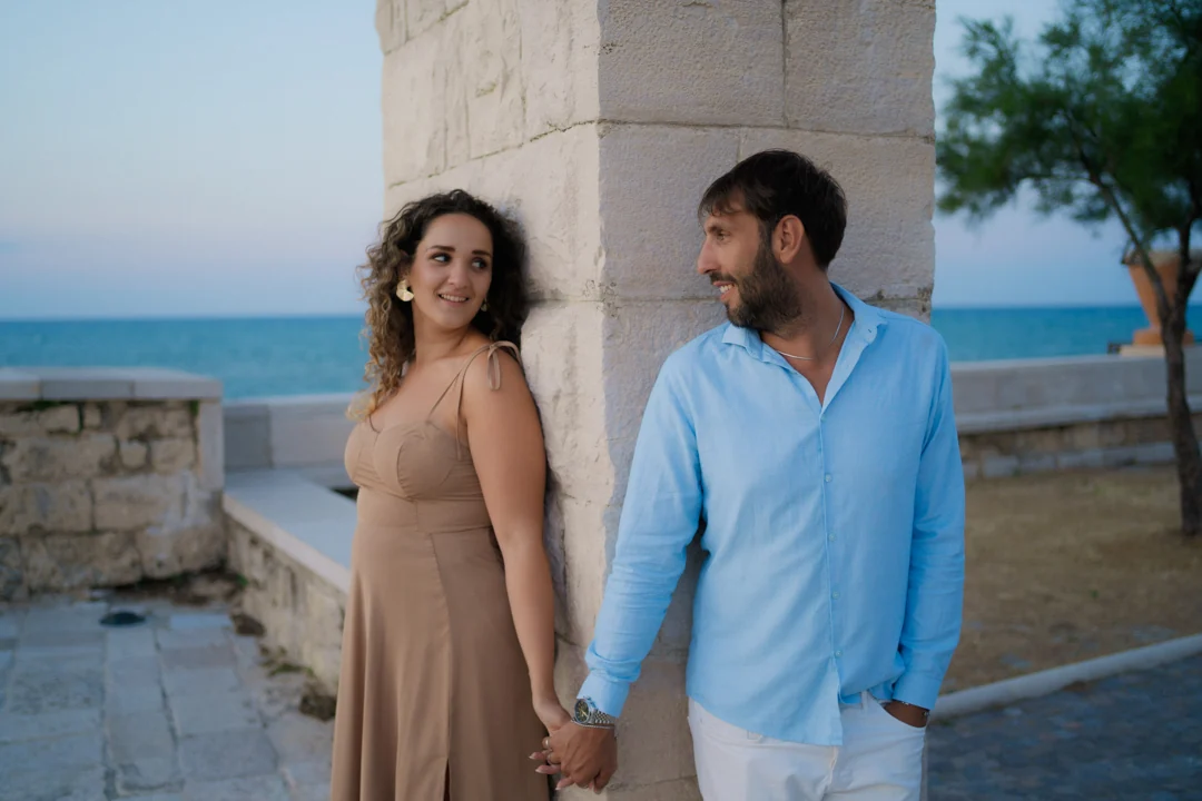 Mano nella mano accanto a una colonna sul mare